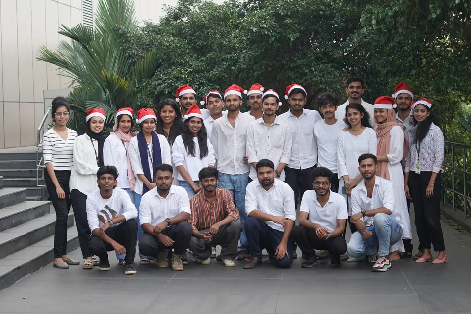 Trogon teammates in white outfits and Santa hats outside the office